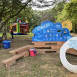 A Playful Learning structure, including wooden bench seating, a sign with illustrations of local birds, and a photo opportunity shaped like an egg which says "Which Cobbs Creek Bird Are You Going to Be Today?"