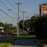 A SEPTA trolley passes the Penrose Plaza strip mall on Island Avenue.