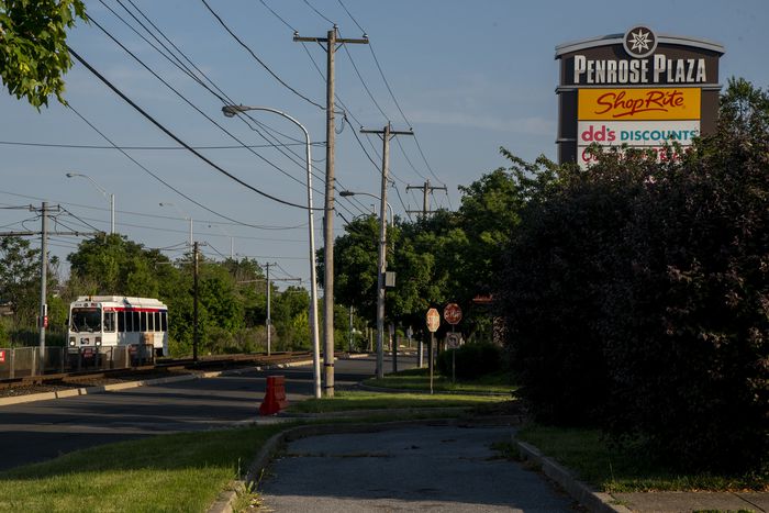 A SEPTA trolley passes the Penrose Plaza strip mall on Island Avenue.